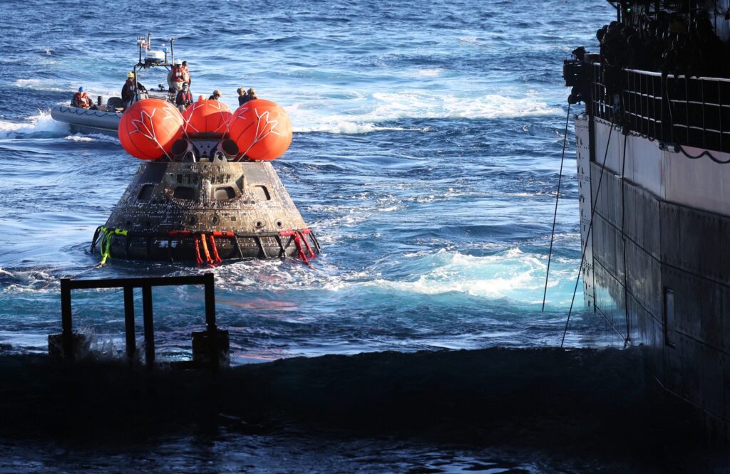 NASA's Orion Capsule is drawn to the well deck of the U.S.S. Portland after it splashed down following a successful uncrewed Artemis I Moon Mission on December 11, 2022 in the Pacific Ocean off the coast of Baja California, Mexico